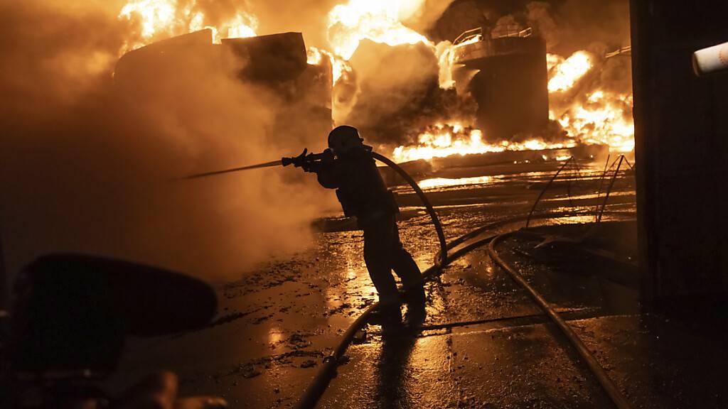 Feuerwehrleute löschen ein Feuer nach einem russischen Angriff auf ein Wohnviertel. Foto: Yevhen Titov/AP/dpa