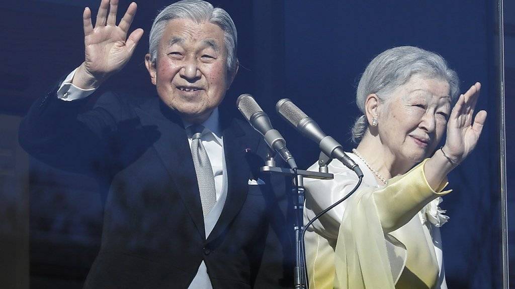 Kaiser Akihito und Kaiserin Michiko winken ihren Anhängern zu.