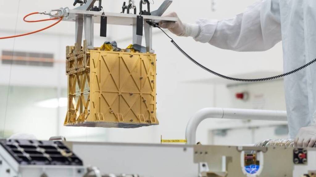 HANDOUT - Techniker in einem Nasa-Labor führen das wissenschaftliche Gerät namens «Moxie» in das Innere des Mars-Rover «Perseverance» ein. Foto: -/Nasa/JPL-Caltech/dpa - ACHTUNG: Nur zur redaktionellen Verwendung und nur mit vollständiger Nennung des vorstehenden Credits