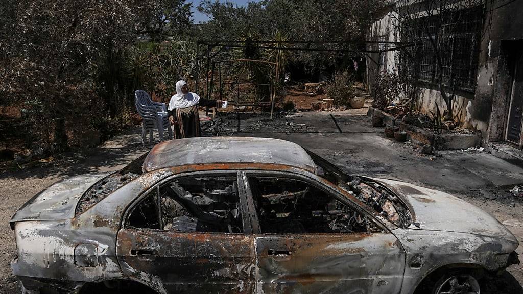 ARCHIV - Eine palästinensische Frau steht neben ihrem abgebrannten Haus, nachdem es von jüdischen Siedlern in Brand gesteckt worden war. Foto: Mahmoud Illean/AP/dpa