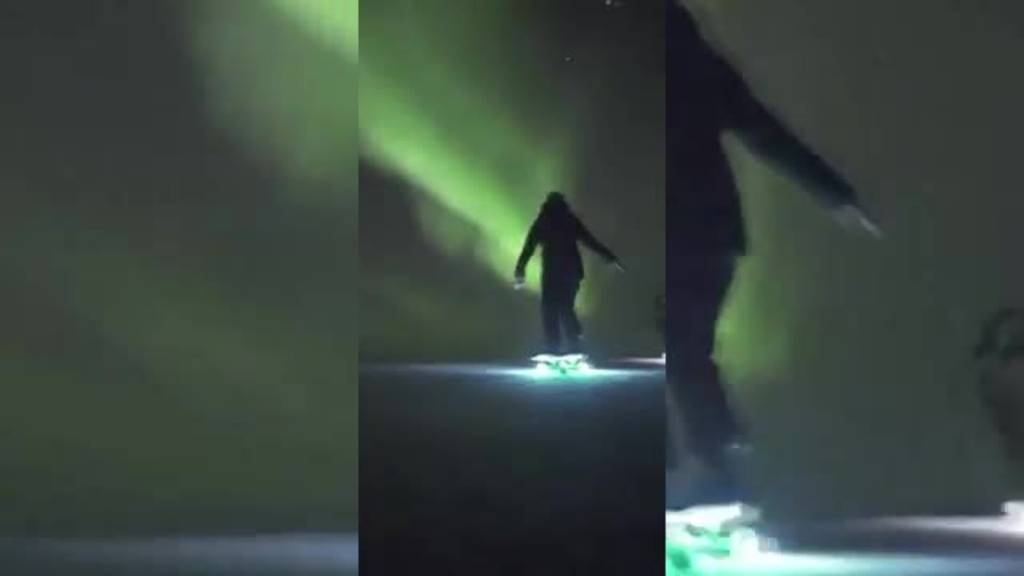 Schweizer Surfskater fahren im Schein vom Polarlicht