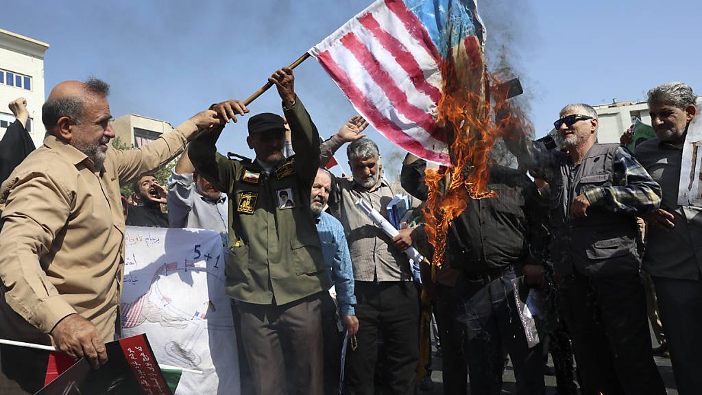 ARCHIV - Iranische Demonstranten verbrennen eine US-amerikanische Fahne in Teheran. Foto: Vahid Salemi/AP/dpa