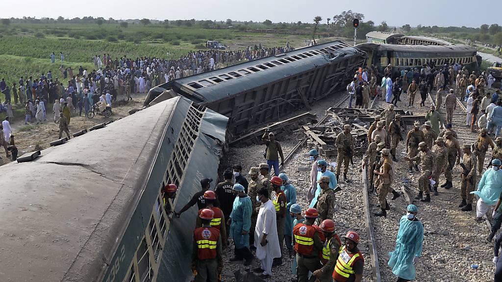 Rettungskräfte und Soldaten versuchen Menschen aus einem entgleisten Zug in Pakistan zu retten. Foto: Pervez Masih/AP/dpa