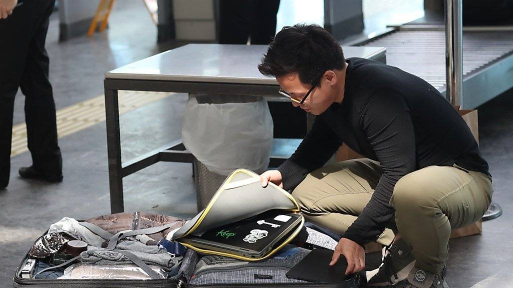 Ein Reisender verstaut am Atatürk-Flughafen in Istanbul seinen Laptop im Aufgabe-Gepäck.
