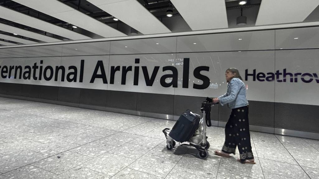 ARCHIV - Eine Reisende kommt am Terminal 5 auf dem Flughafen Heathrow an. Foto: Kirsty Wigglesworth/AP/dpa/Symbolbild