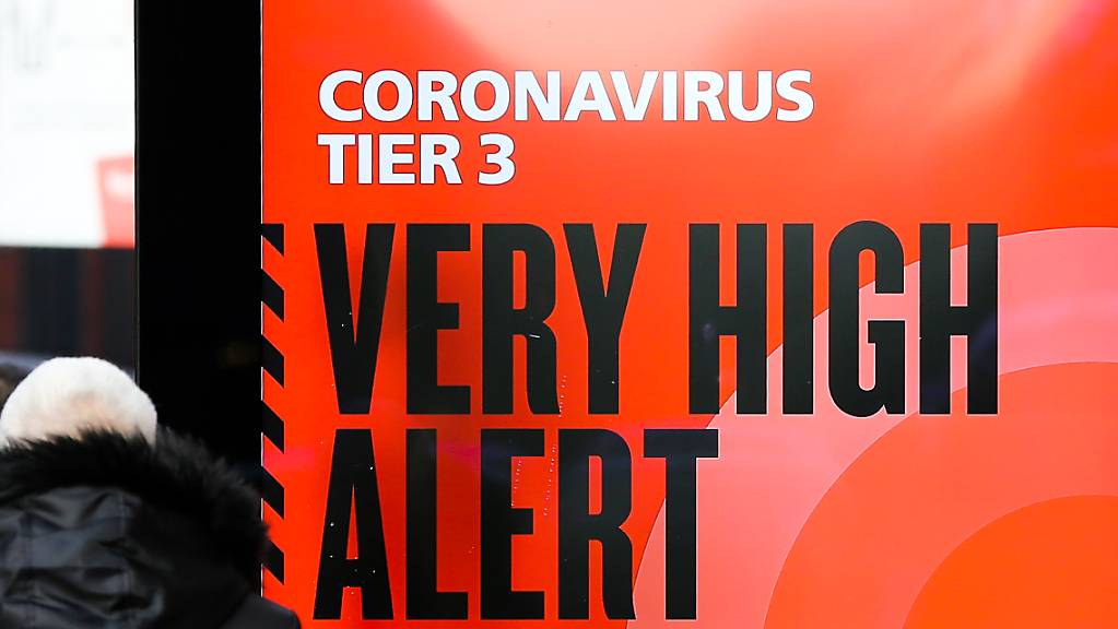 Ein Plakat des britischen Gesundheitsdienstes NHS mit der Aufschrift «Coronavirus Tier 3. Very high alert» (Coronavirus Stufe 3. Sehr hohe Alarmstufe) steht in der Londoner Innenstadt.
