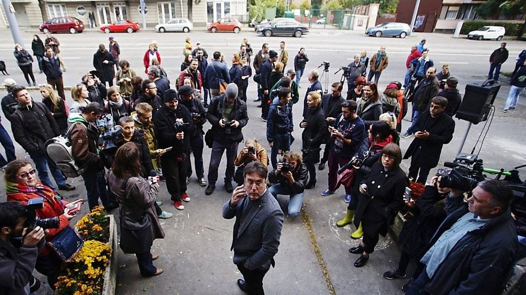 Chefredaktor Andras Muranyi (in der Mitte) und Mitarbeiter der Oppositionszeitung standen am Sonntag vor verschlossenen Redaktionsräumen.