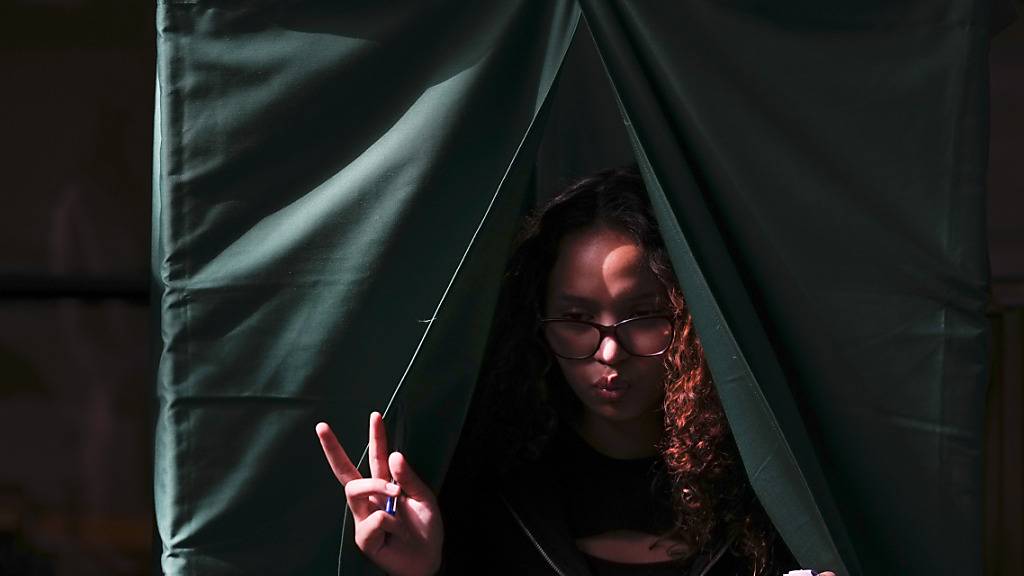 Eine Wählerin hält ihren Stimmzettel in der Hand, nachdem sie ihre Präferenzen für den Entwurf einer neuen Verfassung festgelegt hat. Foto: Esteban Felix/AP/dpa