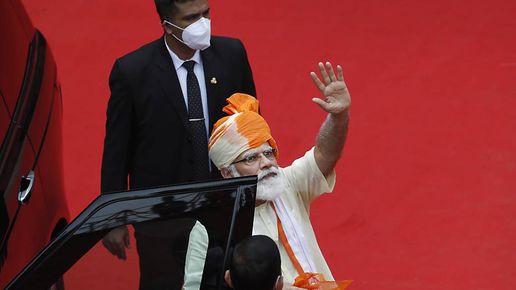 Narendra Modi (r), Premierminister von Indien, winkt, nachdem er am Unabhängigkeitstag vor den Stadtmauern des historischen Red Fort Monuments eine Rede gehalten hat. Foto: Manish Swarup/AP/dpa