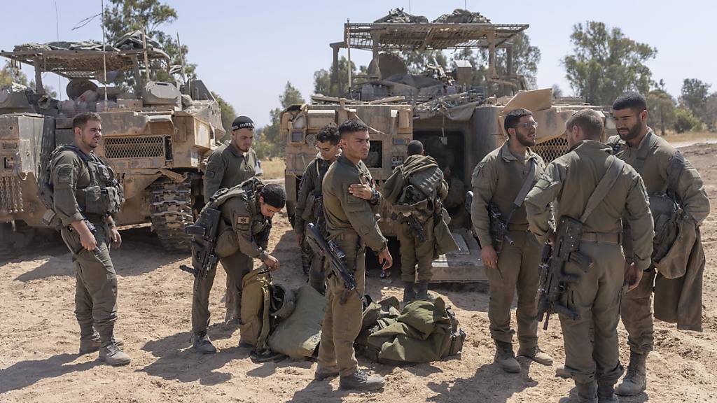 ARCHIV - Israelische Soldaten stehen neben Mannschaftstransportern in der Nähe der Grenze zwischen Israel und Gaza, im Süden Israels. Foto: Ohad Zwigenberg/AP/dpa