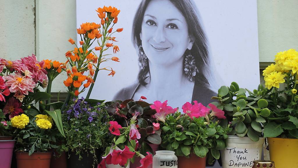 ARCHIV - Kerzen und Blumen stehen im Gedenken vor einem Foto der ermordeten maltesischen Journalistin Daphne Caruana Galizia vor dem Justizpalast. Foto: Lena Klimkeit/dpa