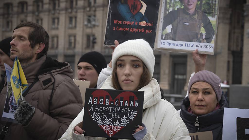 Angehörige von ukrainischen Soldaten, die von Russland gefangen genommen wurden, halten ihre Fotos mit der Forderung ihrer Freilassung. Foto: Efrem Lukatsky/AP/dpa