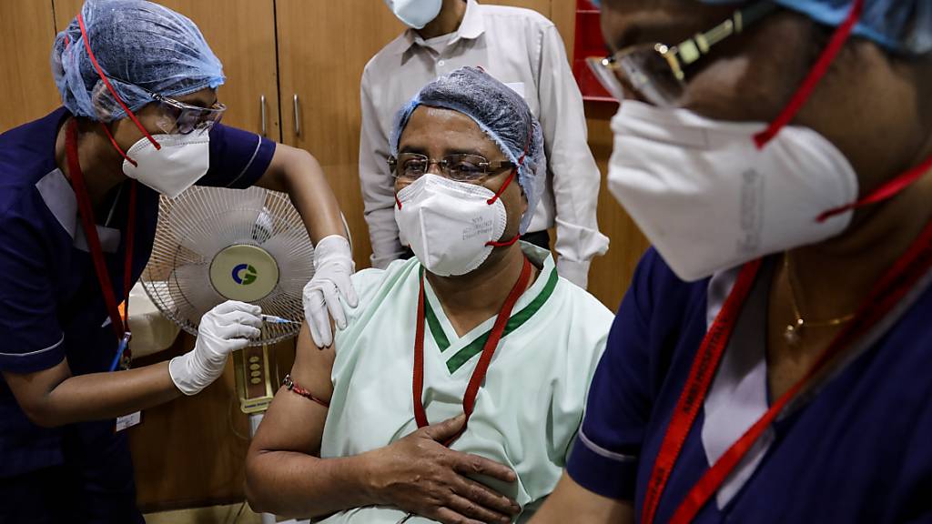 In Kolkata erhält eine Mitarbeiterin des Gesundheitswesens eine Impfung gegen das Coronavirus. Foto: Bikas Das/AP/dpa