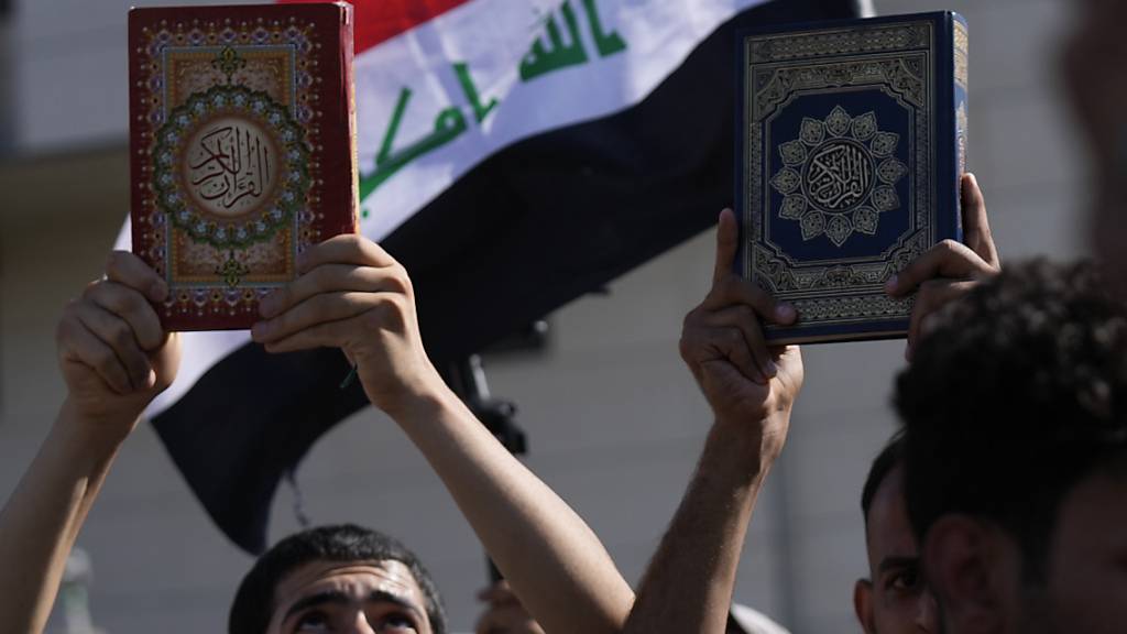 ARCHIV - Anhänger des schiitischen Geistlichen Muqtada al-Sadr halten den Koran während einer Demonstration vor der schwedischen Botschaft in Reaktion auf die Koranverbrennung in Schweden hoch. Foto: Hadi Mizban/AP/dpa