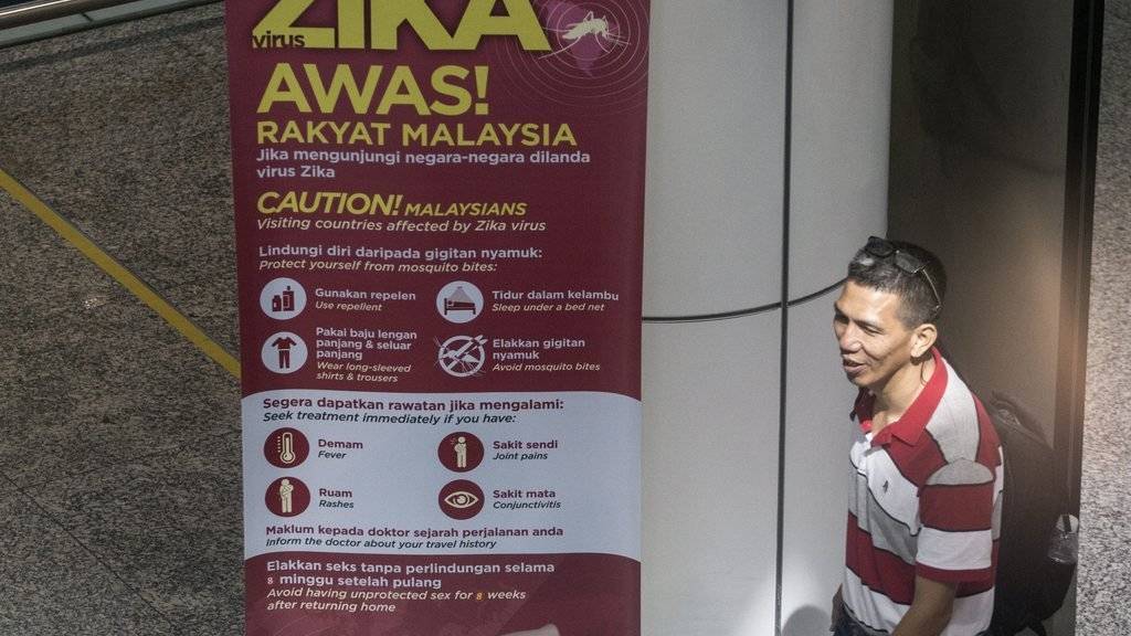 Ein Plakat informiert am Flughafen von Kuala Lumpur Reisende über das Zika-Virus. (Archiv)
