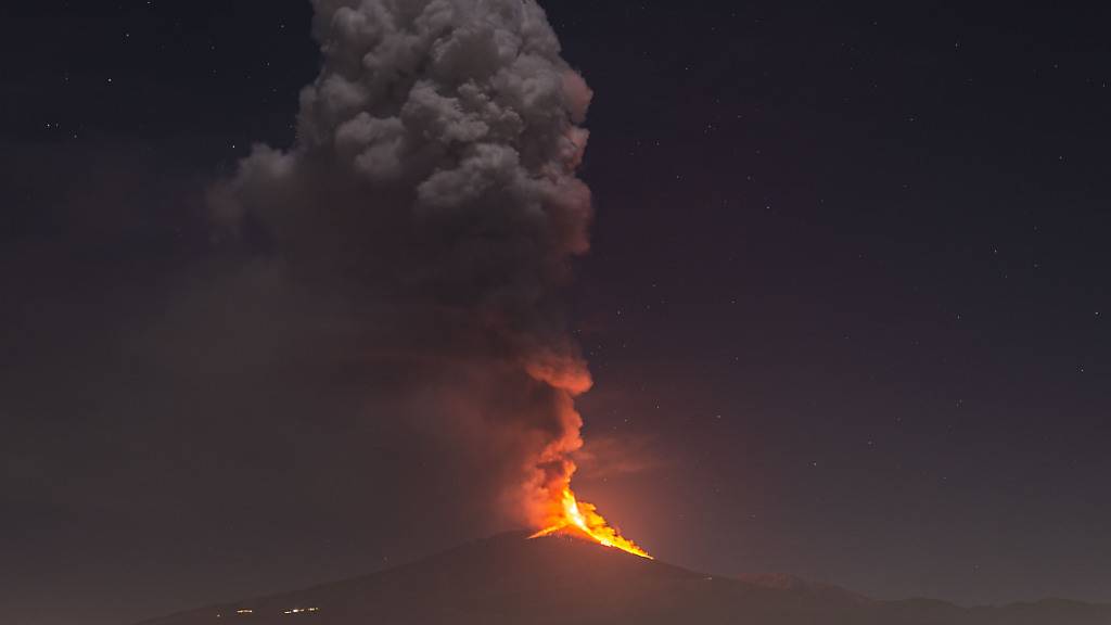 Flammen und Rauch steigen aus dem Vulkans Ätna auf und überragen die Stadt Pedara auf Sizilien. Foto: Salvatore Allegra/AP/dpa