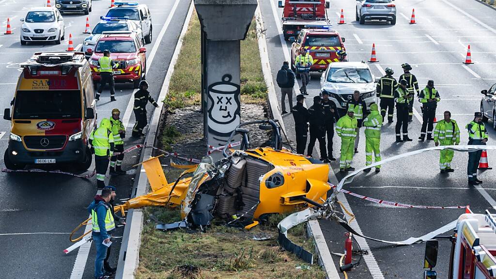 Ein Hubschrauber liegt nach einem Unfall auf der Autobahn M-40 in Madrid. Der Hubschrauber ist aus bisher ungeklärter Ursache am Freitag auf die viel befahrene Ringautobahn M-40 rund um die spanische Hauptstadt Madrid gestürzt. Foto: Matias Chiofalo/EUROPA PRESS/dpa
