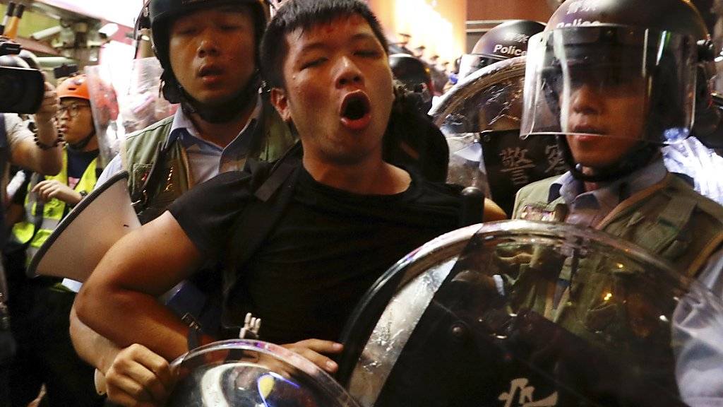 Polizisten in Hongkong führen am Sonntag einen Demonstranten ab.