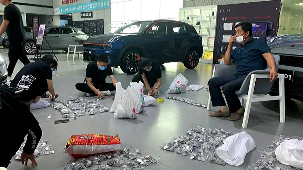 Hier kauft ein Mann ein Auto mit Kleingeld