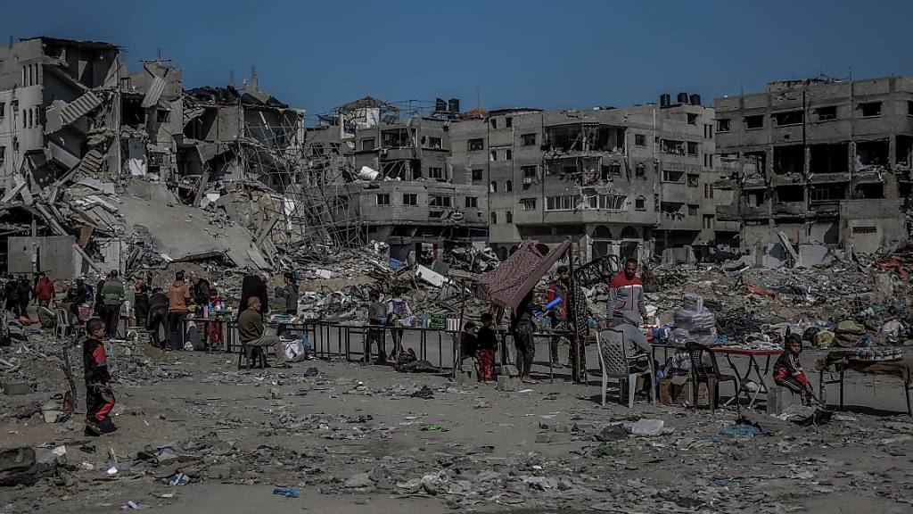 ARCHIV - Palästinenser sitzen nach dem Rückzug der israelischen Armee aus dem Norden des Gazastreifens neben beschädigten Gebäuden auf dem Weg zurück in ihre Häuser. Foto: Omar Ishaq/dpa