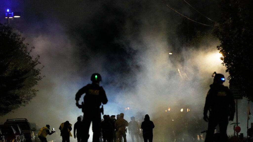 dpatopbilder - Polizeibeamte stehen vor einer Einrichtung der US-amerikanischen Einwanderungs- und Zollbehörde. Foto: Jenny Kane/AP/dpa