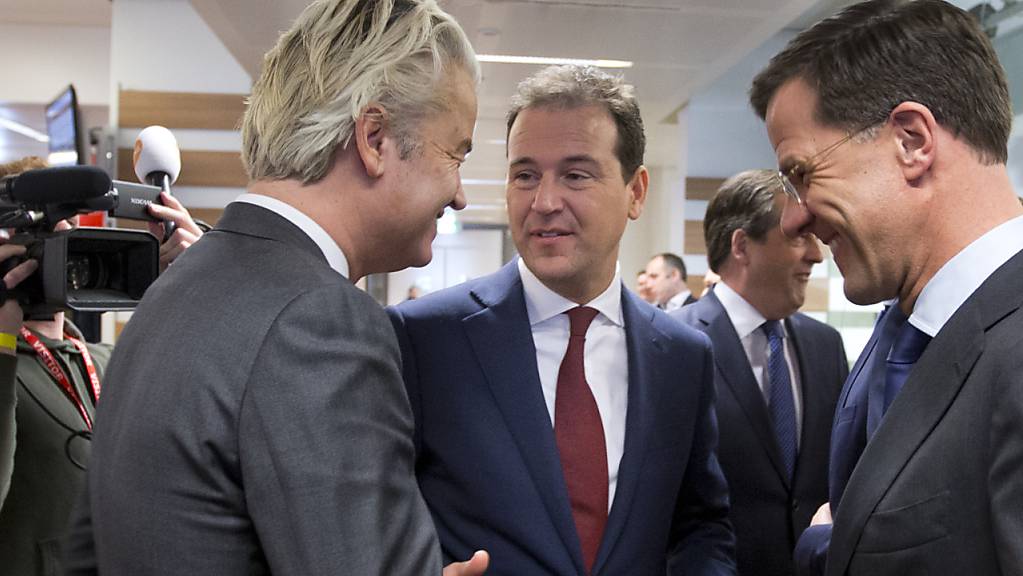 ARCHIV - Geert Wilders (l), Vorsitzender der niederländischen rechtspopulistischen Partei für die Freiheit (PVV) begrüsst Ministerpräsident Mark Rutte (VVD, r) und Vizepremier Lodewijk Asscher (PVDA) bei einem Besuch bei der niederländischen Tageszeitung De Telegraaf. Foto: Peter Dejong/AP/dpa