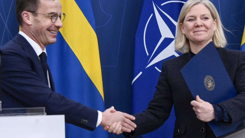 ARCHIV - Schwedens Ministerpräsident Ulf Kristersson (l) und seine Vorgängerin Magdalena Andersson geben sich die Hand. Foto: Lars Schröder/TT/TT News Agency/AP/dpa
