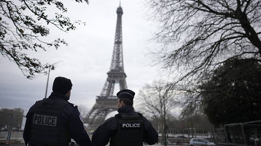 dpatopbilder - Französische Polizisten patrouillieren in der Nähe des Eiffelturms. Foto: Christophe Ena/AP/dpa