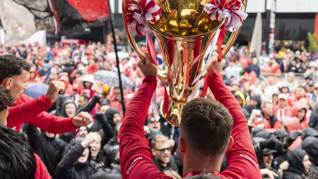 Torhüter Niklas Steffen stemmt den Pokal des Schweizer Fussballmeisters in die Höhe.