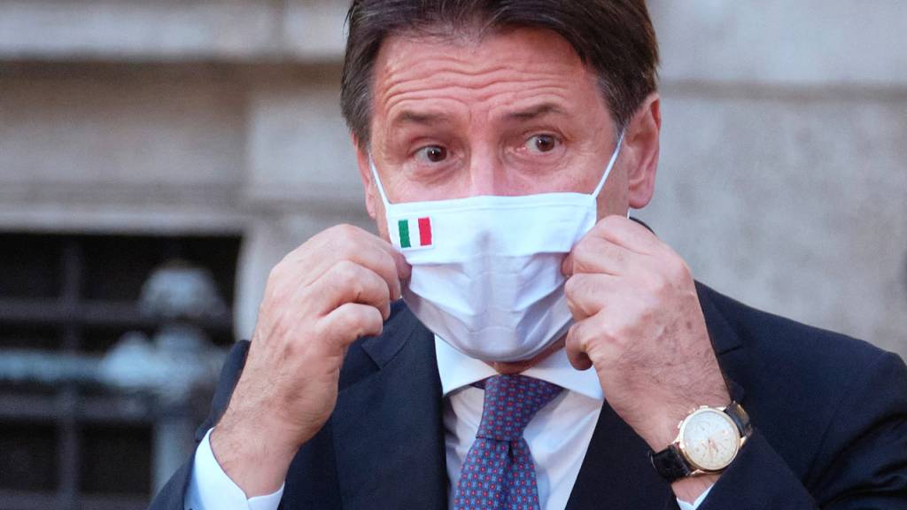 ARCHIV - Giuseppe Conte, Ministerpräsident von Italien, richtet seinen Mund-Nasen-Schutz bei einer Pressekonferenz. Foto: Mauro Scrobogna/LaPresse/AP/dpa