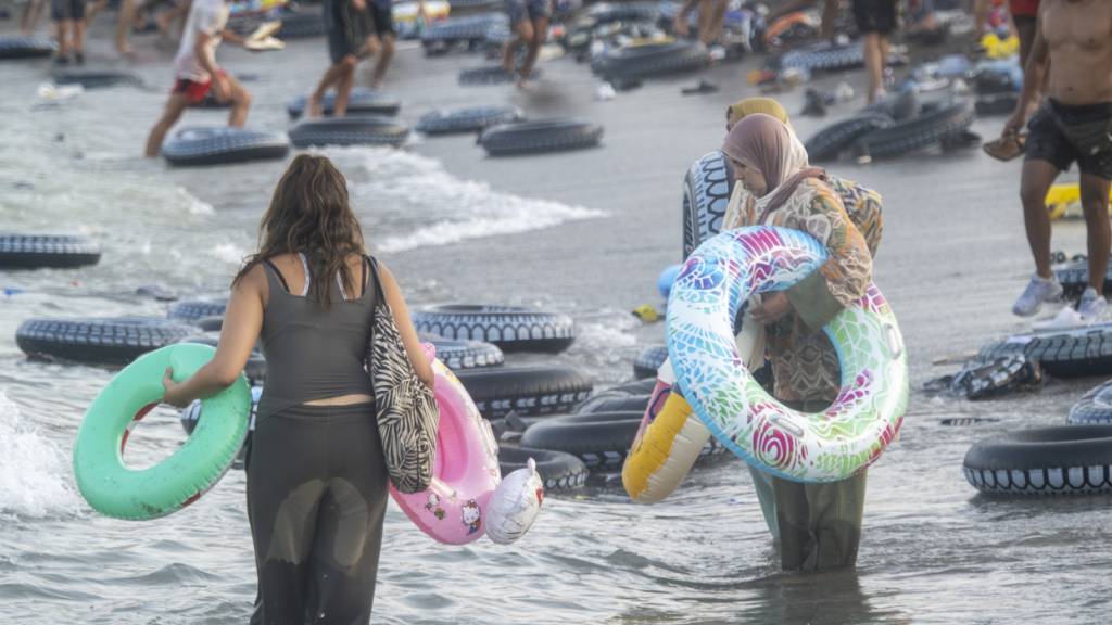 Migranten stehen im Wasser beim Versuch, die Grenze zwischen Ceuta und Marokko zu überqueren. Foto: Marcos Moreno/EUROPA PRESS/dpa
