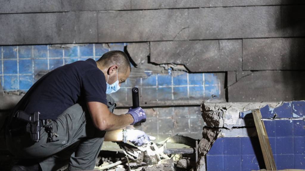 dpatopbilder - Ein Offizier untersucht Trümmer, nachdem eine Rakete aus dem Gazastreifen auf Israel abgefeuert wurde. Foto: Ilia Yefimovich/dpa