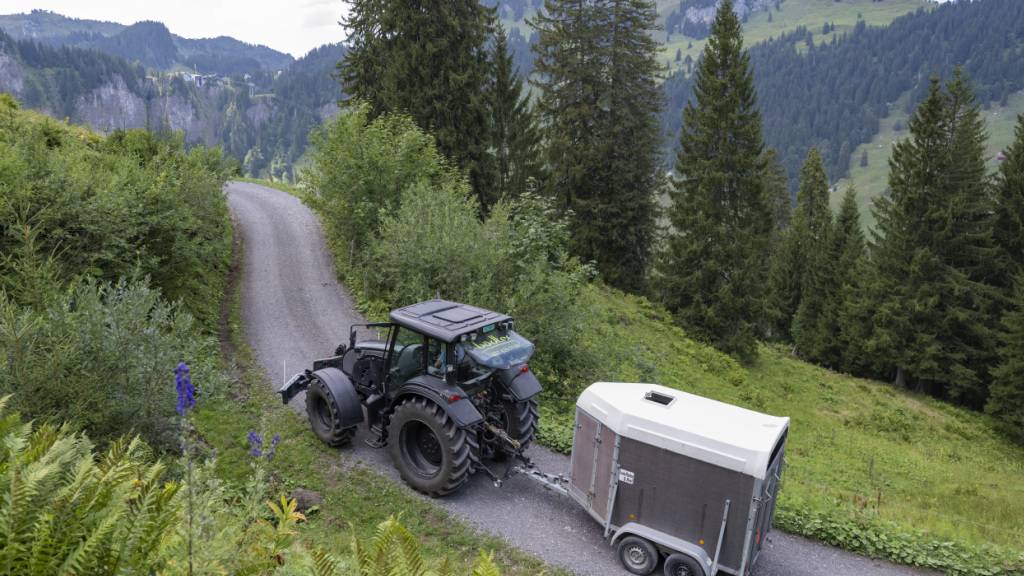 Ein Bewirtschafter transportiert mit seinem Traktor Wasser auf seine Alp. (Archivaufnahme)
