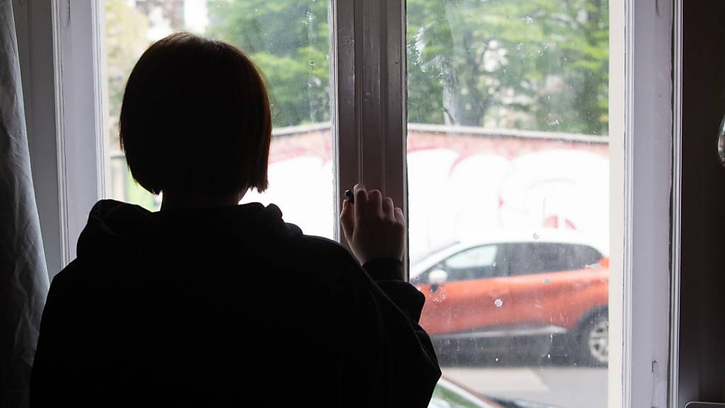 ARCHIV - ILLUSTRATION - Eine Jugendliche blickt aus einem Fenster. Die Pandemie hat bei Kindern und Jugendlichen in England deutliche Spuren bei der psychischen Gesundheit hinterlassen. Foto: Paul Zinken/dpa