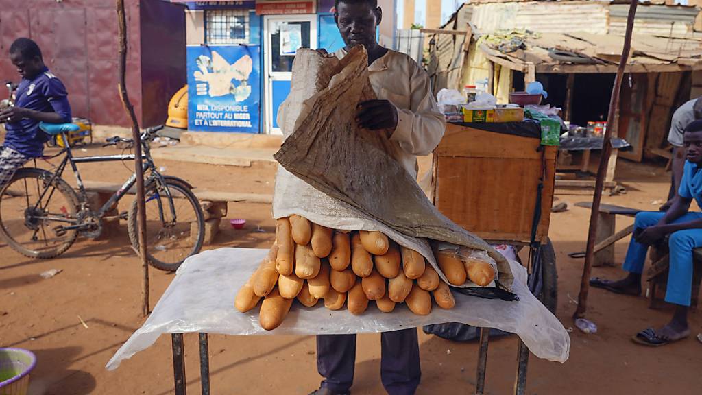 dpatopbilder - Ein Mann verkauft auf einem Markt französisches Baguette. Die Afrikanische Union (AU) unterstützt die von der westafrikanischen Staatengruppe Ecowas gefassten Maßnahmen zur Wiederherstellung der verfassungsmäßigen Ordnung im Niger. Das teilte der AU-Vorsitzende Faki Mahamat mit. Foto: Sam Mednick/AP