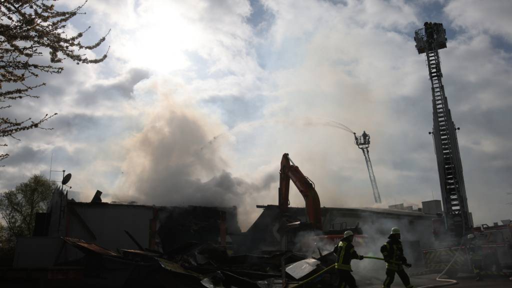 dpatopbilder - Mit schwerem Gerät arbeitet sich die Feuerwehr zu Glutnestern vor nach einem Brand in einem Club. Hunderte Feiernde retteten sich ins Freie. Foto: Philipp von Ditfurth/dpa