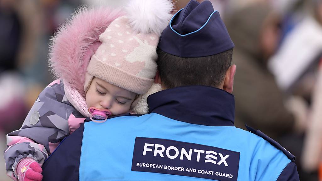 Ein Mitglied der Grenzschutzbehörde Frontex mit einem Flüchtlingskind an der EU-Aussengrenze zwischen der Ukraine und der Slowakei. (Archivaufnahme)