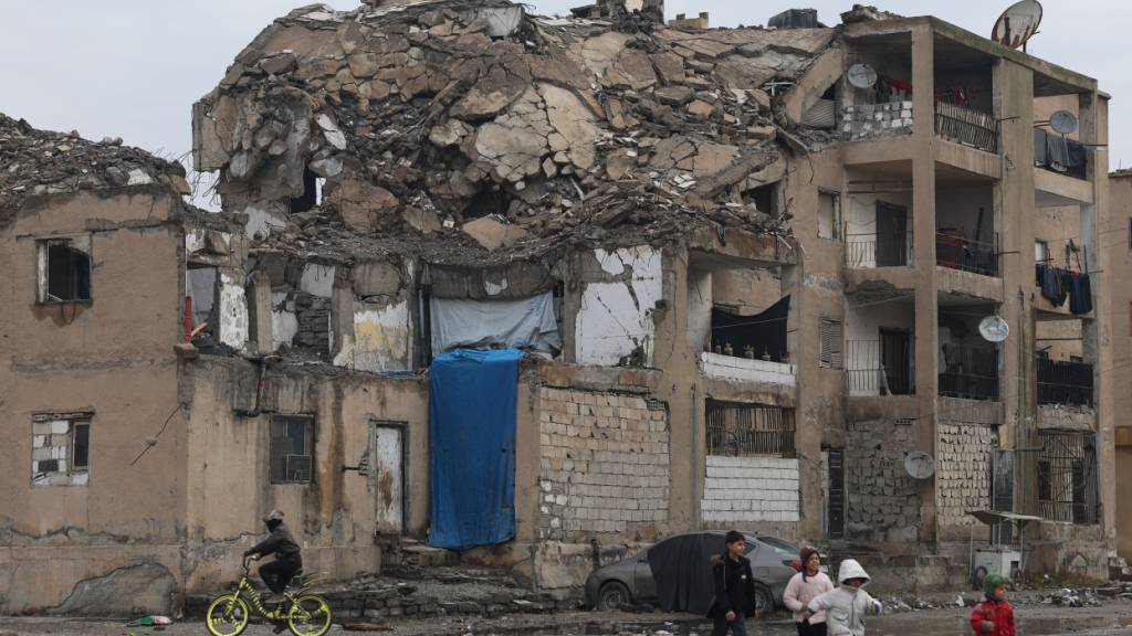 Kinder laufen an einem beschädigten Wohnhaus in Raqqa vorbei. Foto: Ghaith Alsayed/AP/dpa