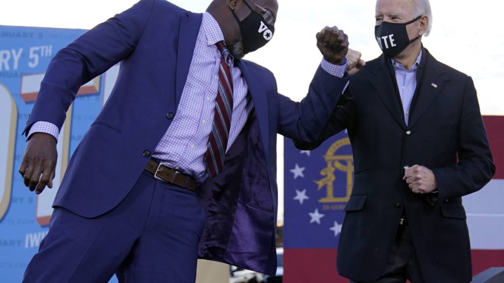 dpatopbilder - Joe Biden (r), gewählter Präsident (President-elect) der USA, steht während einer Wahlkampfveranstaltung neben dem Raphael Warnock, demokratischer Kandidat für den US-Senat, auf der Bühne. Foto: Carolyn Kaster/AP/dpa