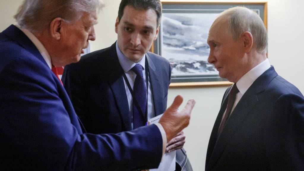 ARCHIV - Auf diesem von der staatlichen russischen Nachrichtenagentur Sputnik via AP veröffentlichten Foto spricht US-Präsident Donald Trump (l) mit dem russischen Präsidenten Wladimir Putin (r) nach ihrer gemeinsamen Pressekonferenz auf der Joint Base Elmendorf-Richardson, Alaska. Foto: Gavriil Grigorov/Pool Sputnik Kremlin/dpa