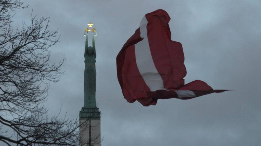 ARCHIV - Eine lettische Fahne weht am Freiheitsdenkmal. Foto: Alexander Welscher/dpa