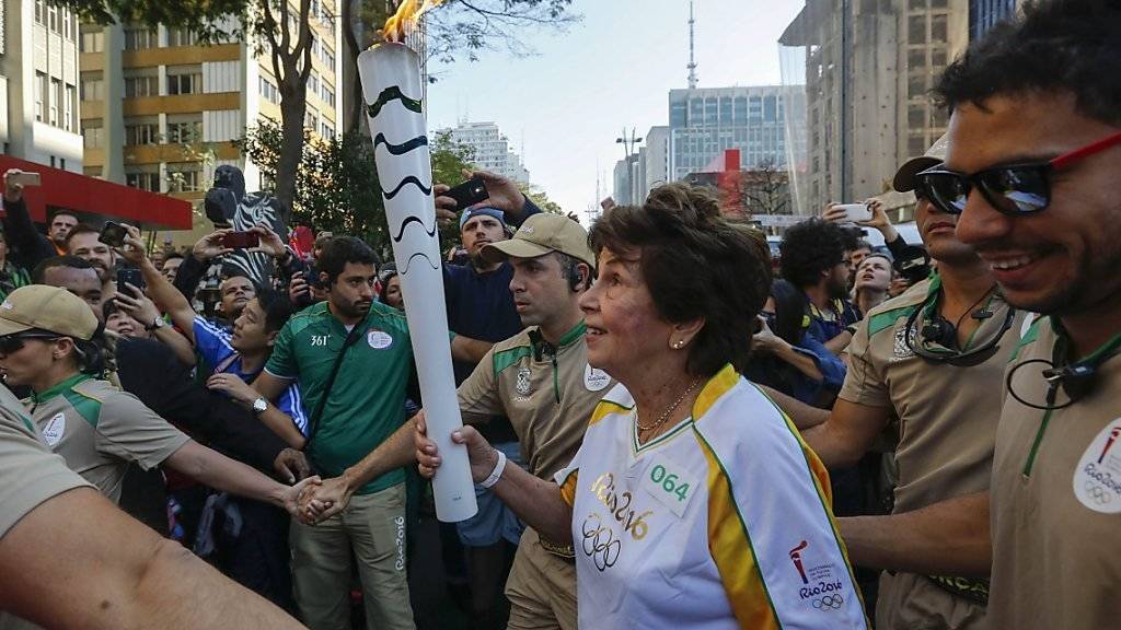 Knapp anderthalb Monate nachdem die frühere brasilianische Tennisspielerin Maria Esther Bueno (im weissen Trikot) mit ihr durch São Paulo gelaufen war, traf die Olympische Flagge wieder in Brasilien ein