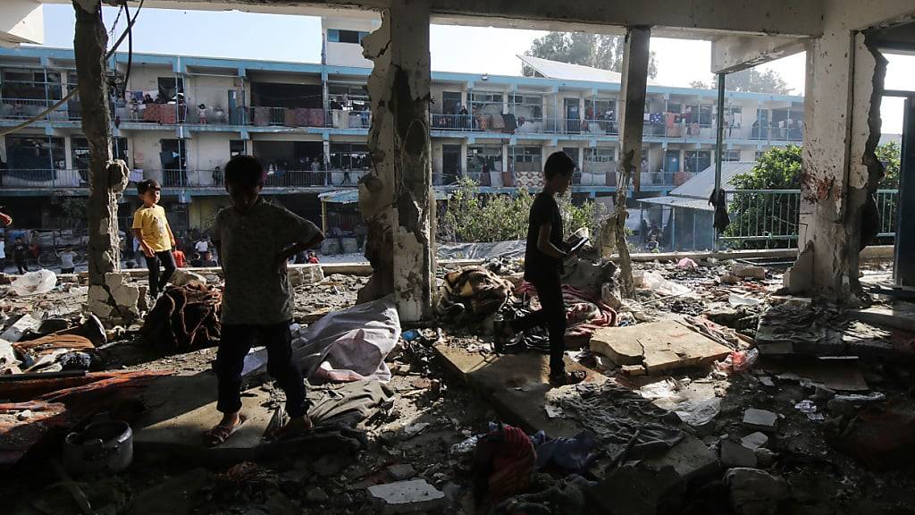 Palästinenser begutachten die Schäden nach einem israelischen Angriff auf eine vom UN-Palästinenserhilfswerk UNRWA betriebene Schule im Flüchtlingslager Nuseirat. Foto: Omar Naaman/dpa
