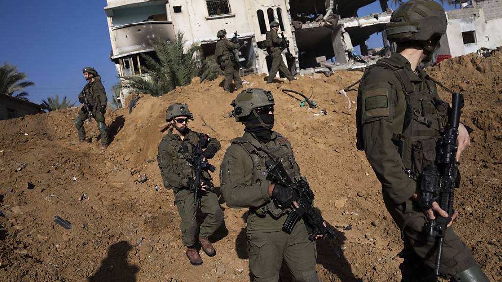 dpatopbilder - Israelische Armeeangehörige stehen neben einem zerstörten Gebäude während einer Bodenoperation. Foto: Ohad Zwigenberg/AP