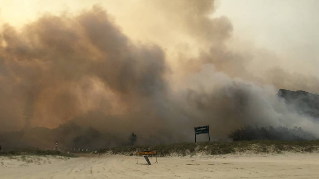 A supplied image obtained on Monday, December 7, 2020, the K'gari (Fraser Island) bushfire seen outside the Cathedrals camping ground, on Fraser Island. TA dangerous bushfire is within a few hundred metres of Happy Valley as dozens of firefighters battle to save the township on Queensland's Fraser Island.. (AAP Image/Supplied by QLD Ambulance Service) NO ARCHIVING, EDITORIAL USE ONLY