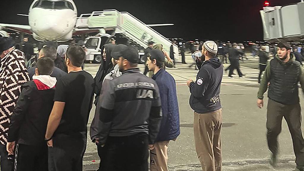 Menschen laufen und rufen antisemitische Parolen auf einem Flugfeld des Flughafens in Machatschkala. Foto: Uncredited/AP
