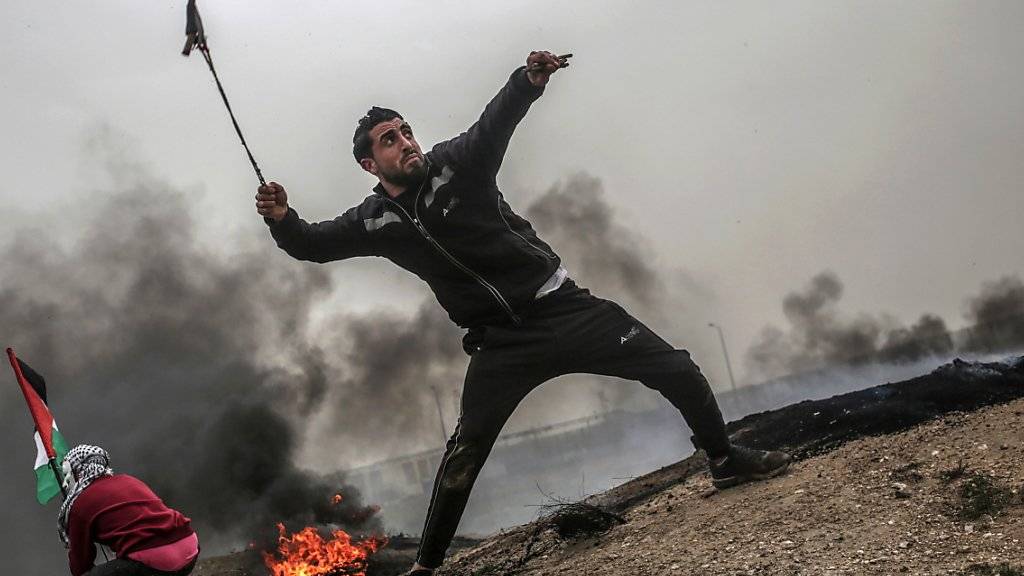 David gegen Goliath: Palästinensische Jugendliche schleudern Geschosse über den Grenzzaun des Gazastreifens gegen israelische Soldaten.