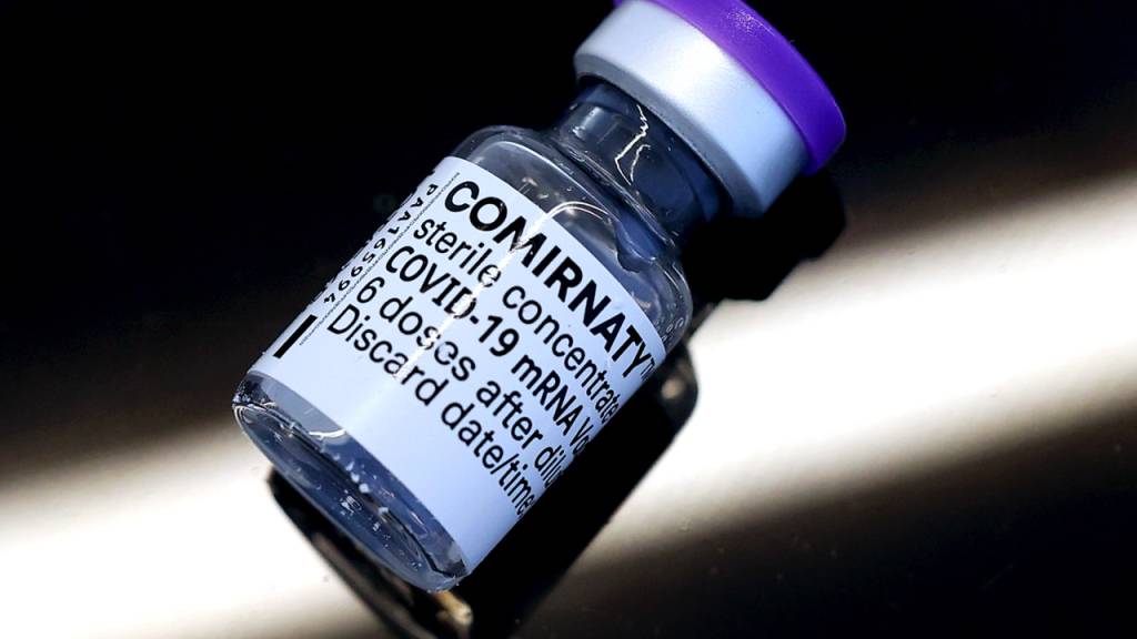 ARCHIV - Eine Ampulle mit dem Corona-Impfstoff Comirnaty der Hersteller Biontech und Pfizer liegt auf einem Tisch. Foto: Ronny Hartmann/dpa