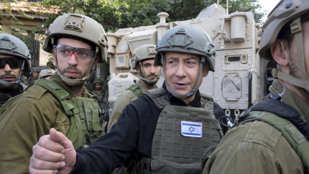 HANDOUT - Benjamin Netanjahu (M), Premierminister von Israel, trägt eine Schutzweste und einen Helm, während er eine Sicherheitsbesprechung mit Kommandeuren und Soldaten abhält. Foto: Avi Ohayon/GPO/AP/dpa - ACHTUNG: Nur zur redaktionellen Verwendung und nur mit vollständiger Nennung des vorstehenden Credits
