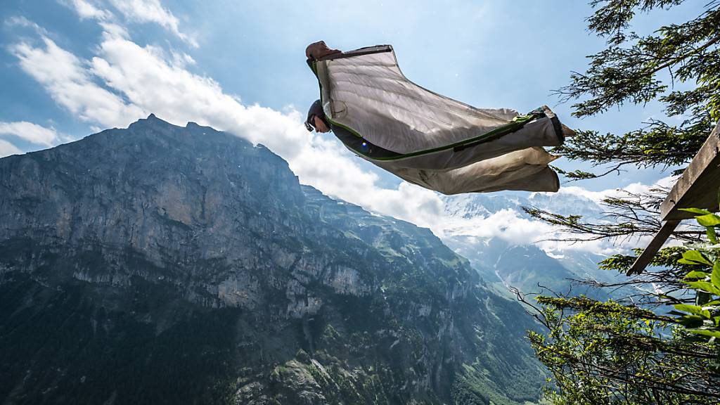 Ein Base-Jumper springt mit seinem Wingsuit in Lauterbrunnen von einem Felsen in die Tiefe. (Archiv)